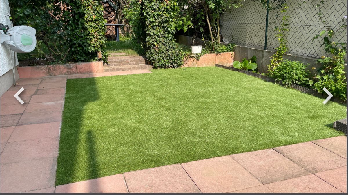 Neu angelegte Rasenfläche mit Beeten